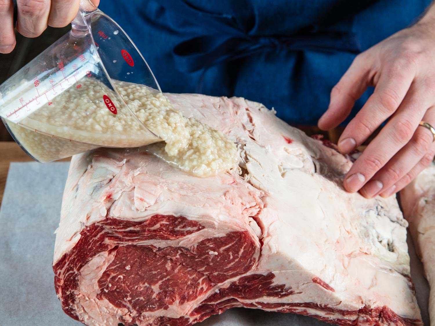 Pouring shio koji over a prime rib roast.