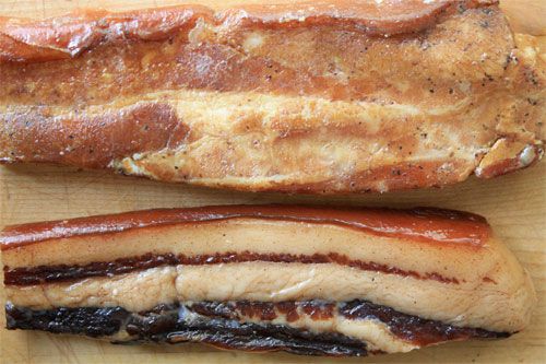 Two slabs of Chinese bacon on a cutting board. 