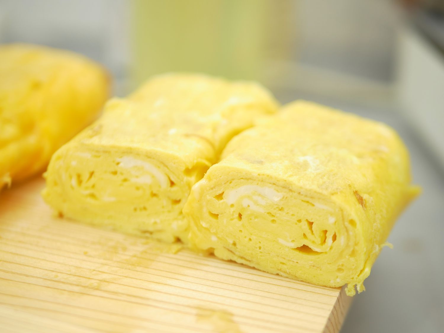a tamagoyaki roll sliced in half to show the layered interior.