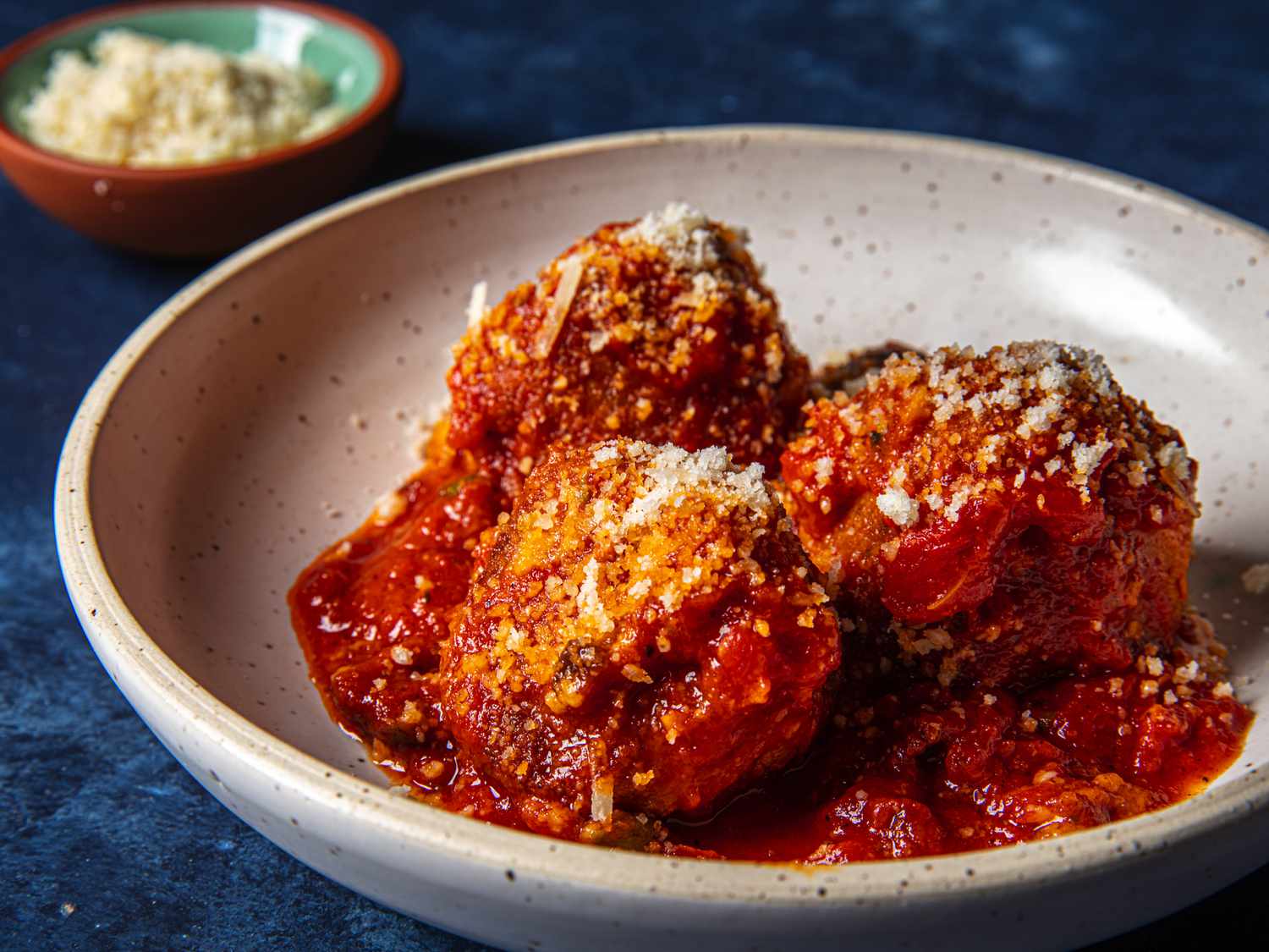 Side angle view of the albondigas de ricottas on a blue background