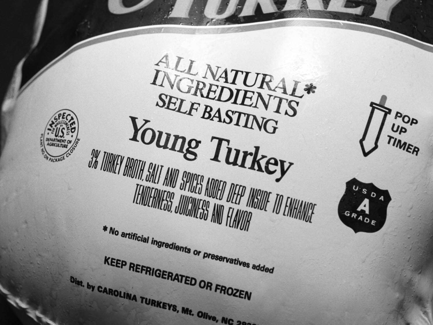 A raw turkey wrapped in plastic at a grocery store.