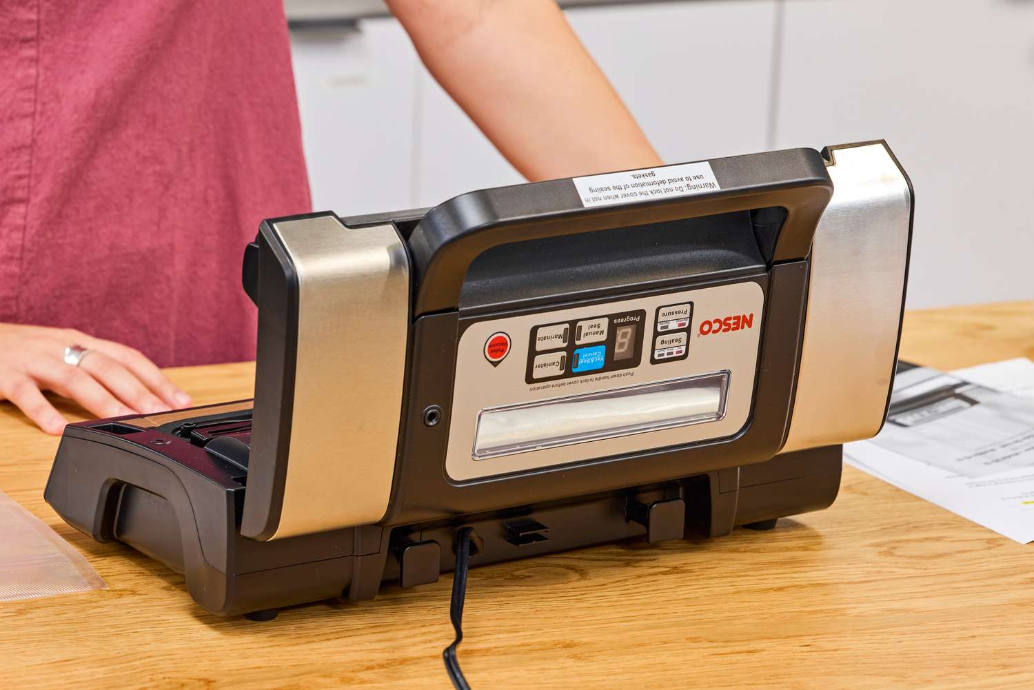 The Nesco VS-12 Deluxe Vacuum Sealer placed on a kitchen countertop