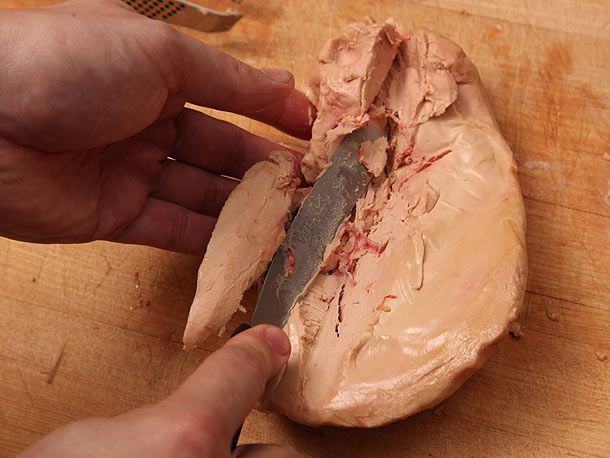Author pressing a lobe half apart with a small metal offset spatula, revealing several veins in the liver's interior.
