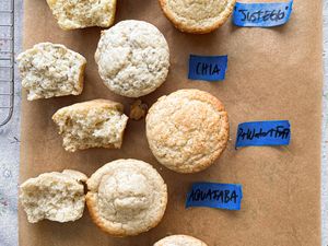 A comparison of muffins made with different egg substitutes labeled Egg Chia Aquafaba and Flax on parchment paper