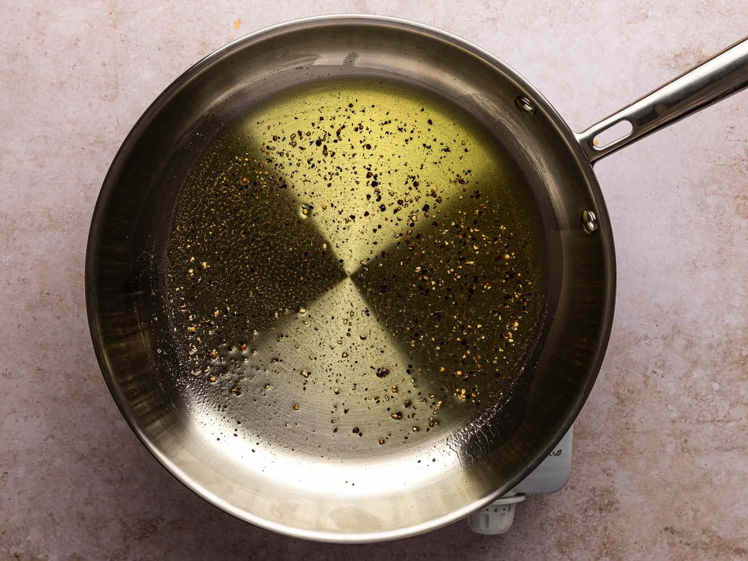 3 tablespoons olive oil and about a teaspoon of black pepper in a medium stainless steel skillet over medium-low heat until ingredients are fragrant and pepper is barely starting to sizzle.