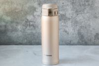 The Zojirushi travel mug on a marble kitchen countertop.