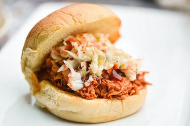 A pulled barbecue chicken sandwich topped with slaw.