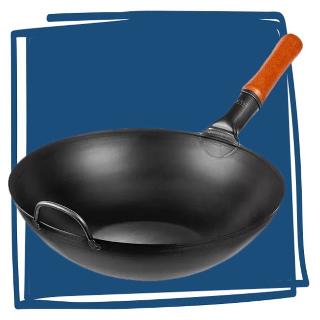 A black wok with a wooden handle against a blue background
