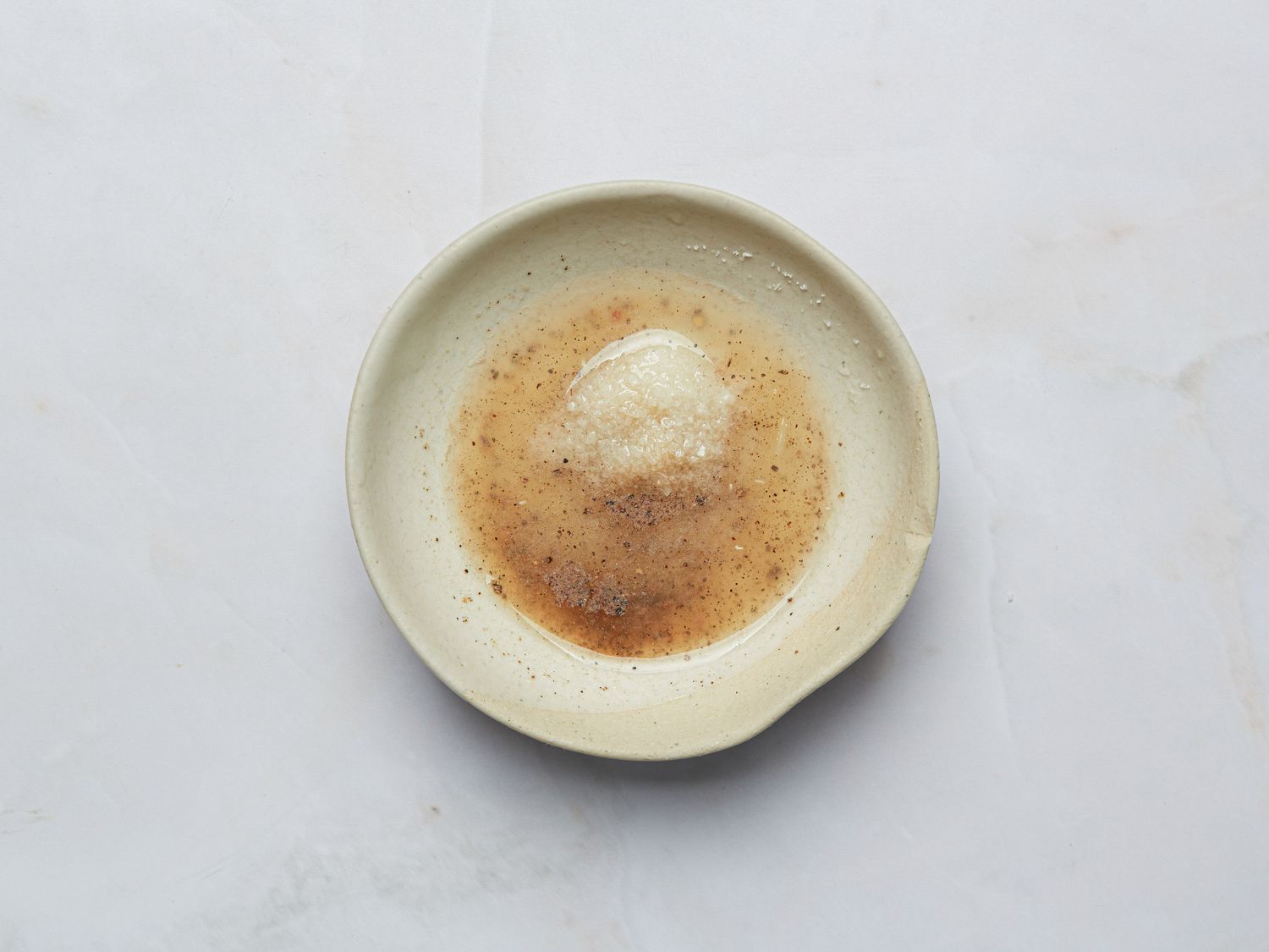 A small bowl with a creamy sauce and rich garnishes