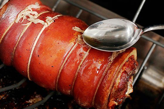 Basting porchetta roast with pan drippings