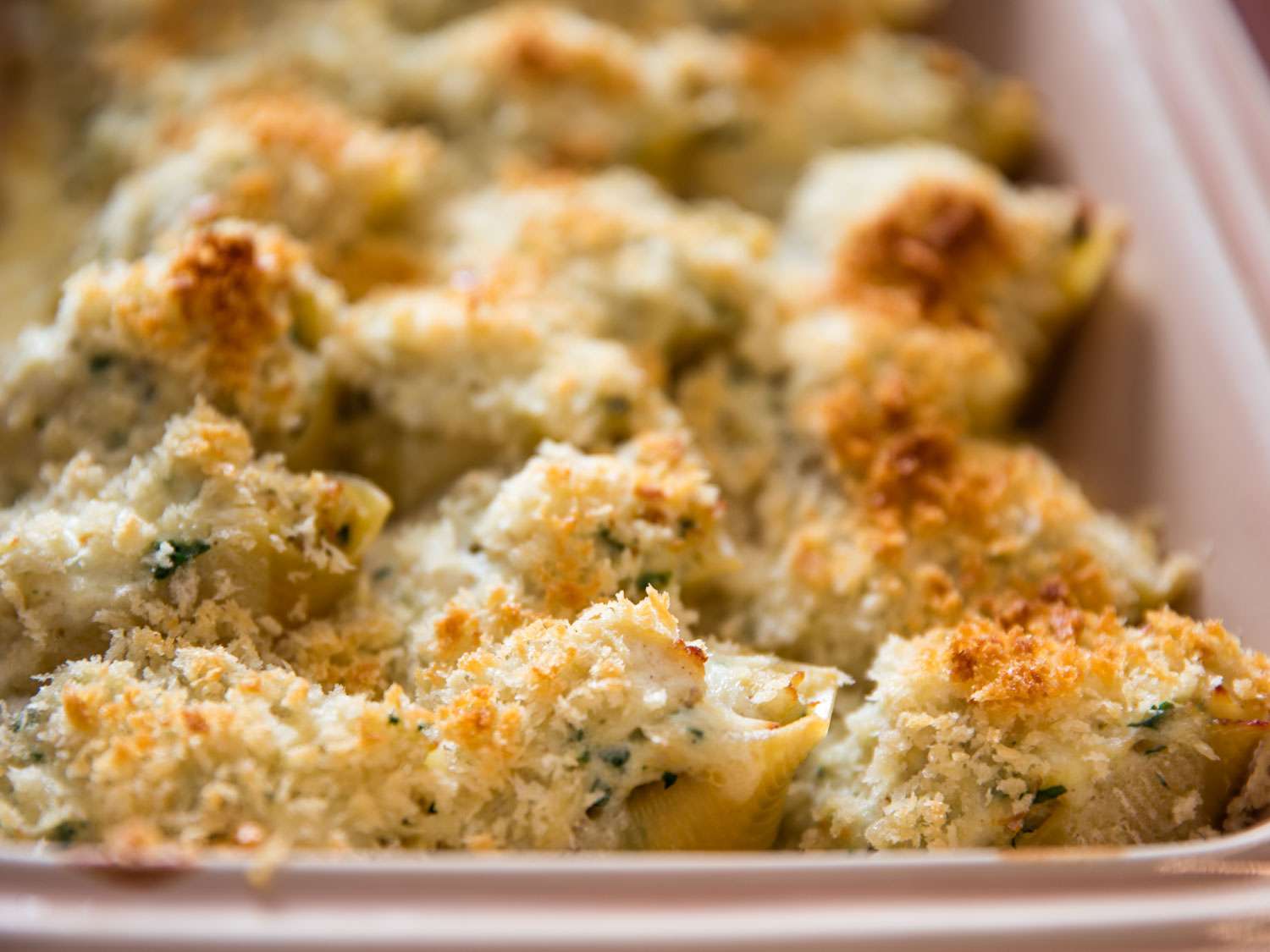 Baked seafood-stuffed pasta shells with crispy golden brown breadcrumb topping.