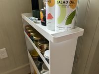 A closeup of the handle of a white kitchen storage rack