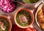 Molokhia soup in a bowl with pickled red onions.