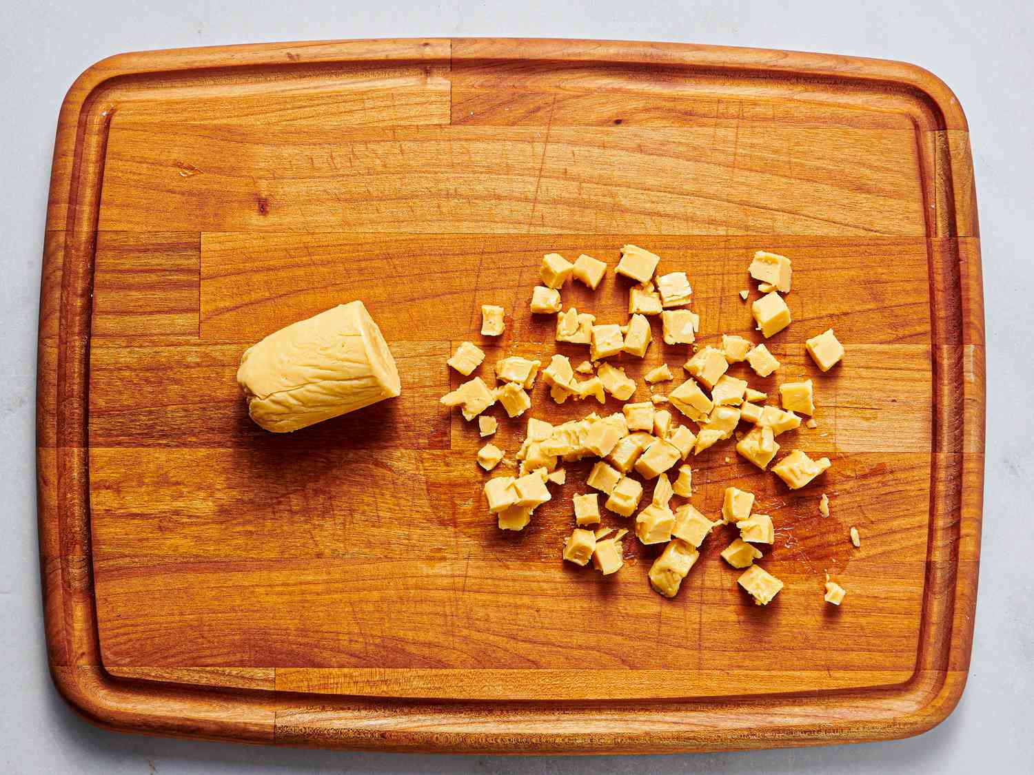 Overhead view of butter cubed on cutting board