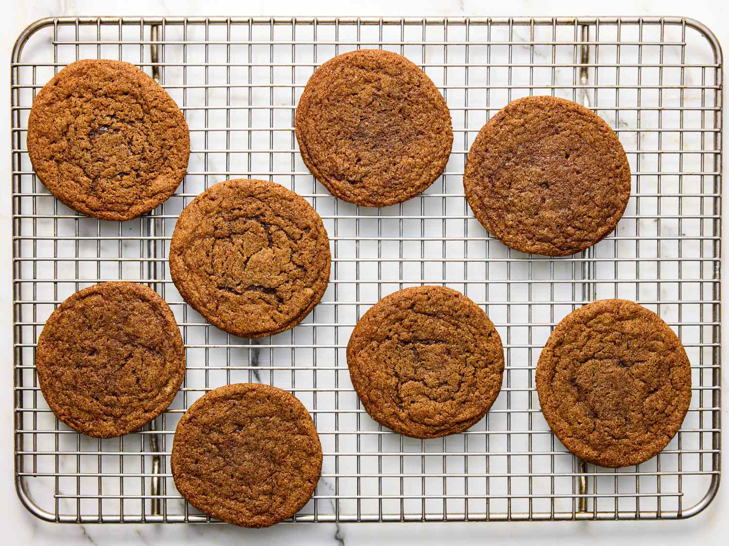 Eight gingerbread cookies cooling on a wire rack