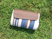 scuddles picnic blanket rolled up on grass