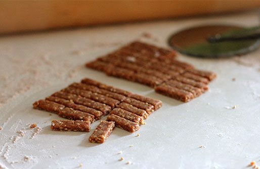 Rolled out squares of sesame dough cut into small sticks with pizza wheel.