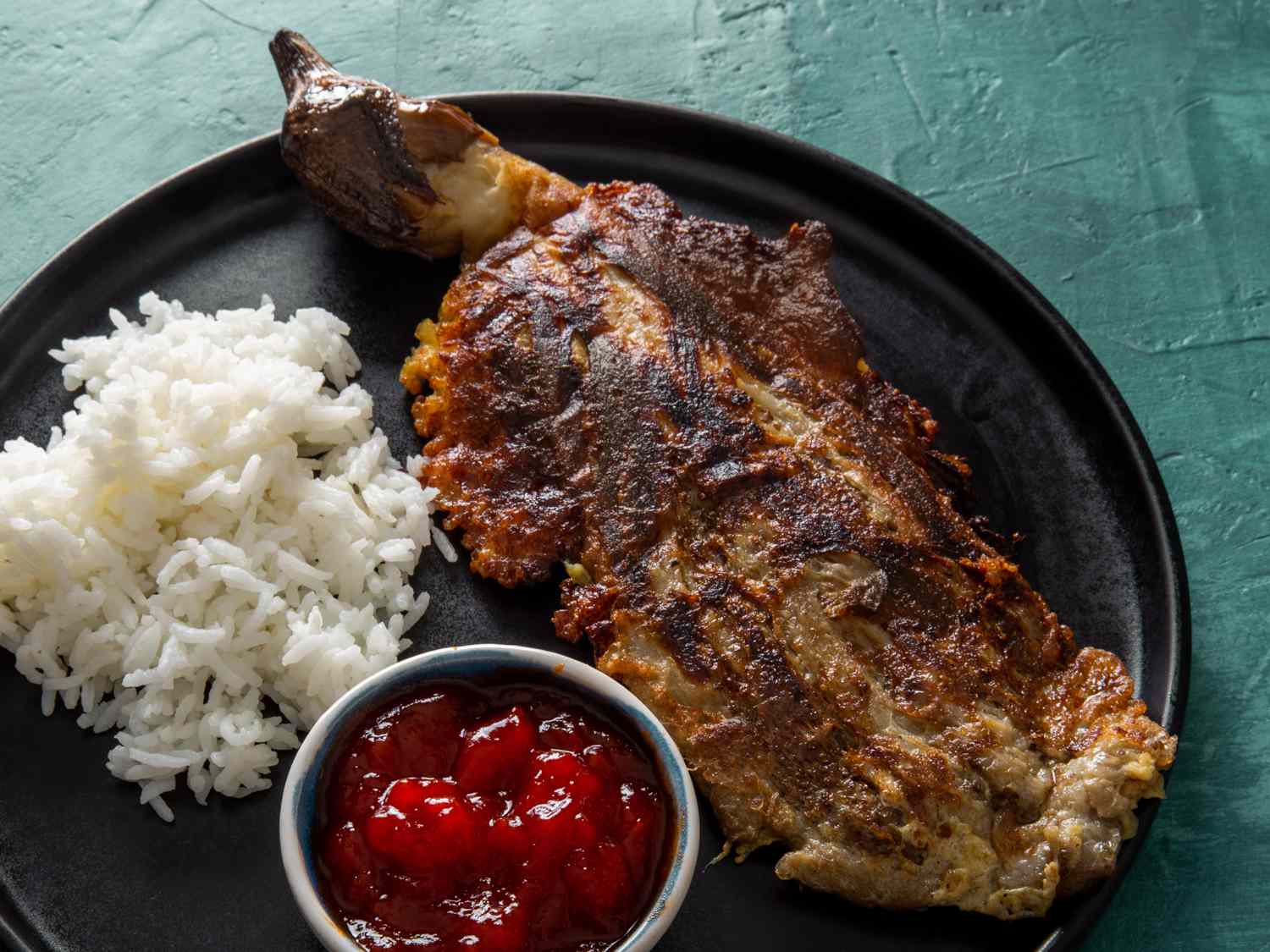 a close up of tortang talong with white rice and banana ketchup