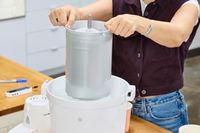 A person placing a bucket into the Hamilton Beach Automatic Ice Cream Maker