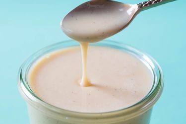 Homemade sweetened condensed milk dripping off a spoon