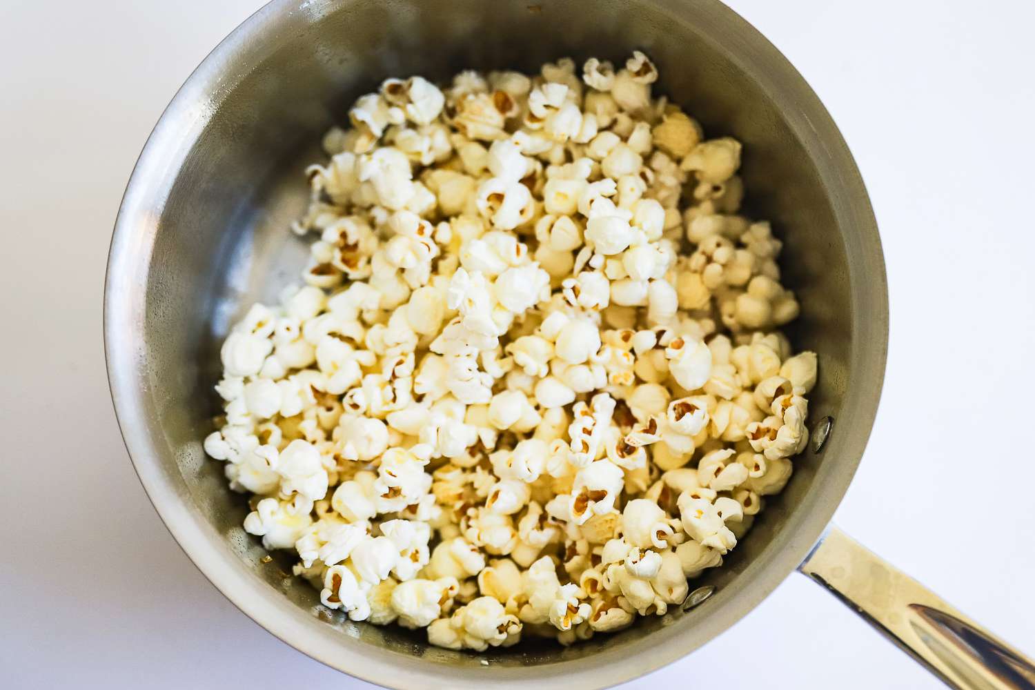 Popcorn cooking in a pot from the All-Clad D3 3-Ply Stainless Steel Cookware Set 10 Piece