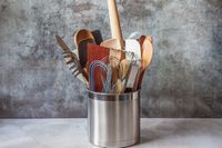 Numerous tools in a stainless steel utensil crock.