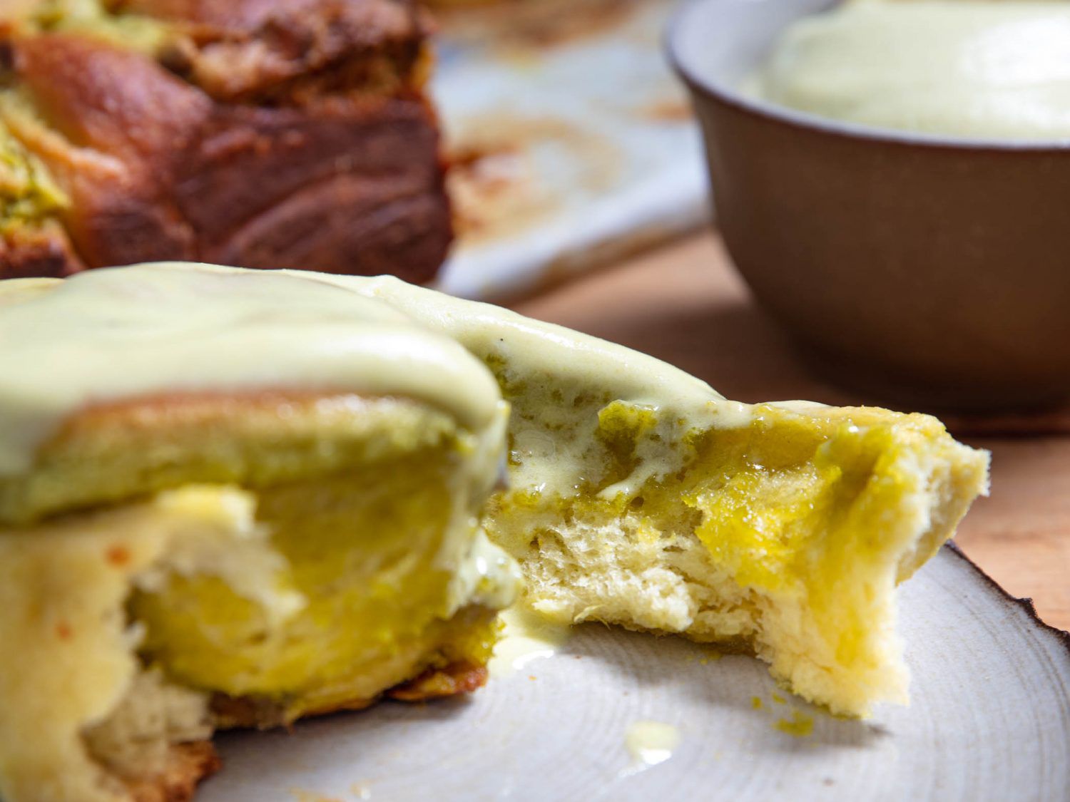 A pistachio bun, torn open to reveal its tender interior.