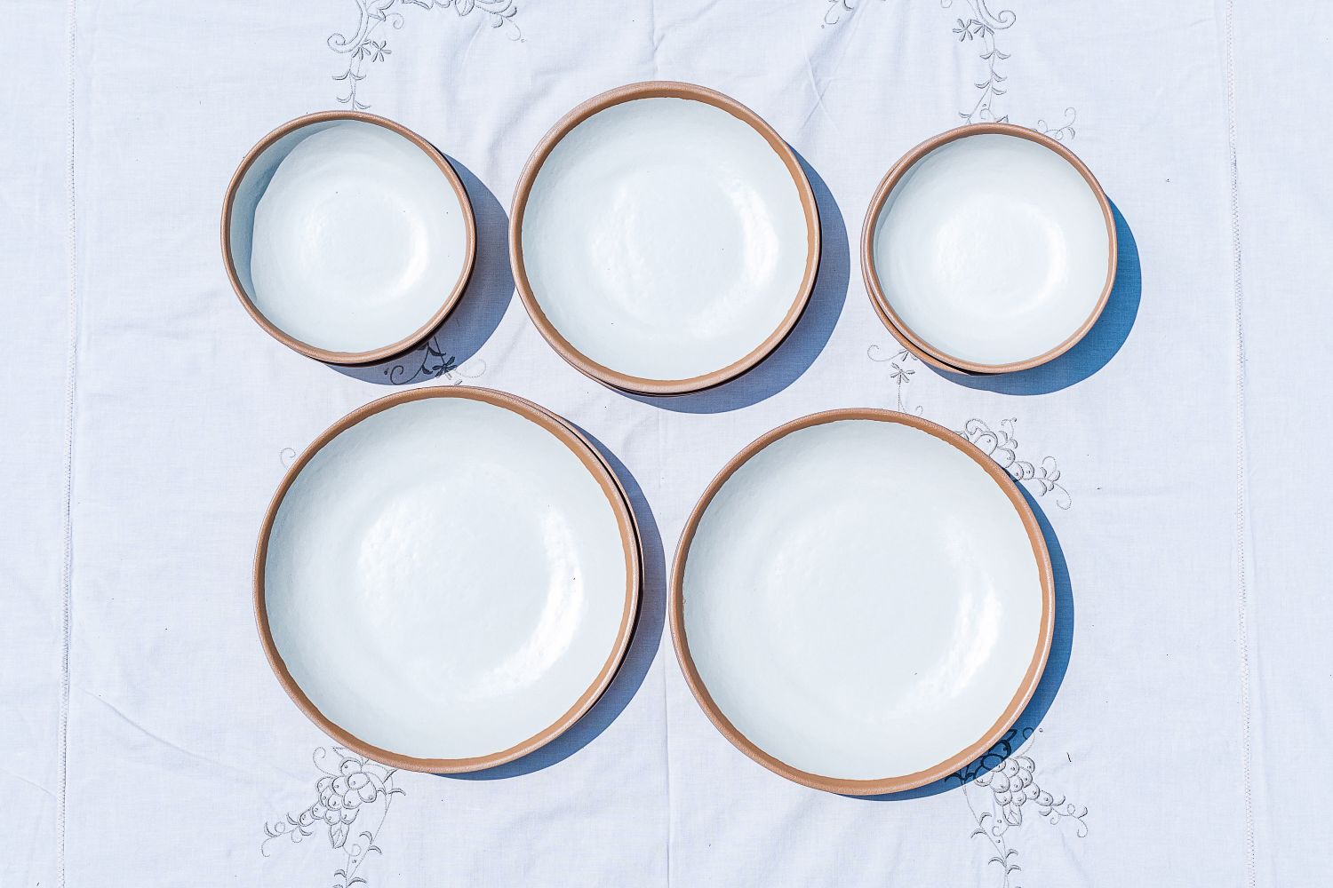 Set of Lulu & Georgia Tara Melamine Dinnerware Set bowls and plates arranged on a patterned tablecloth