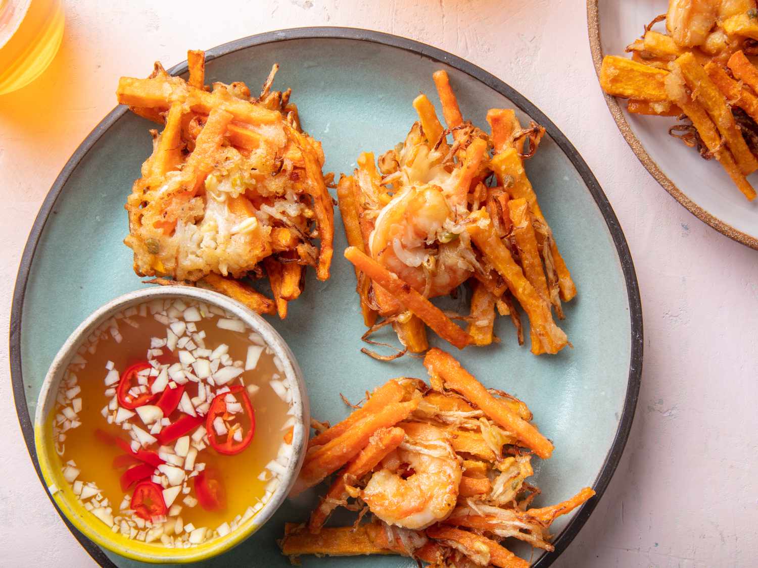 Filipino vegetable and shrimp fritters on plate with dipping sauce