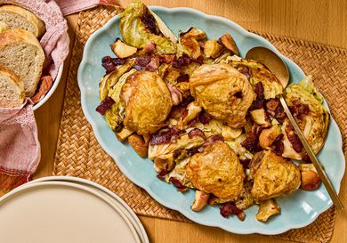 Sheet pan chicken thighs served with bacon and apple on a platter