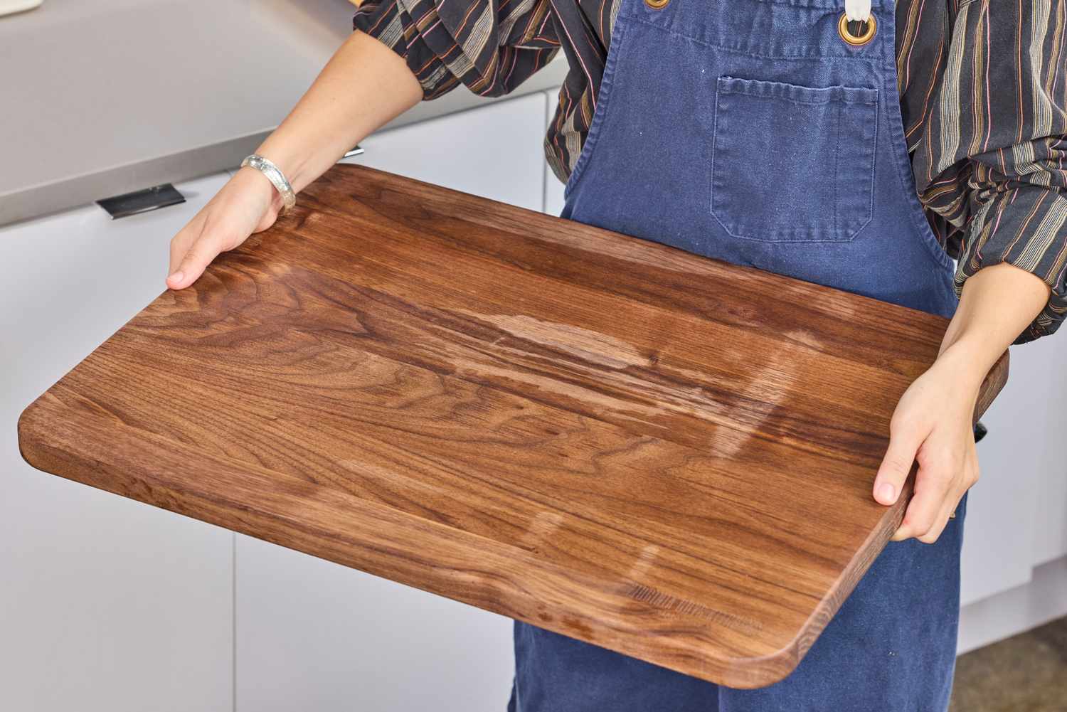 Person holding a Virginia Boys Kitchens Walnut Wood Cutting Board