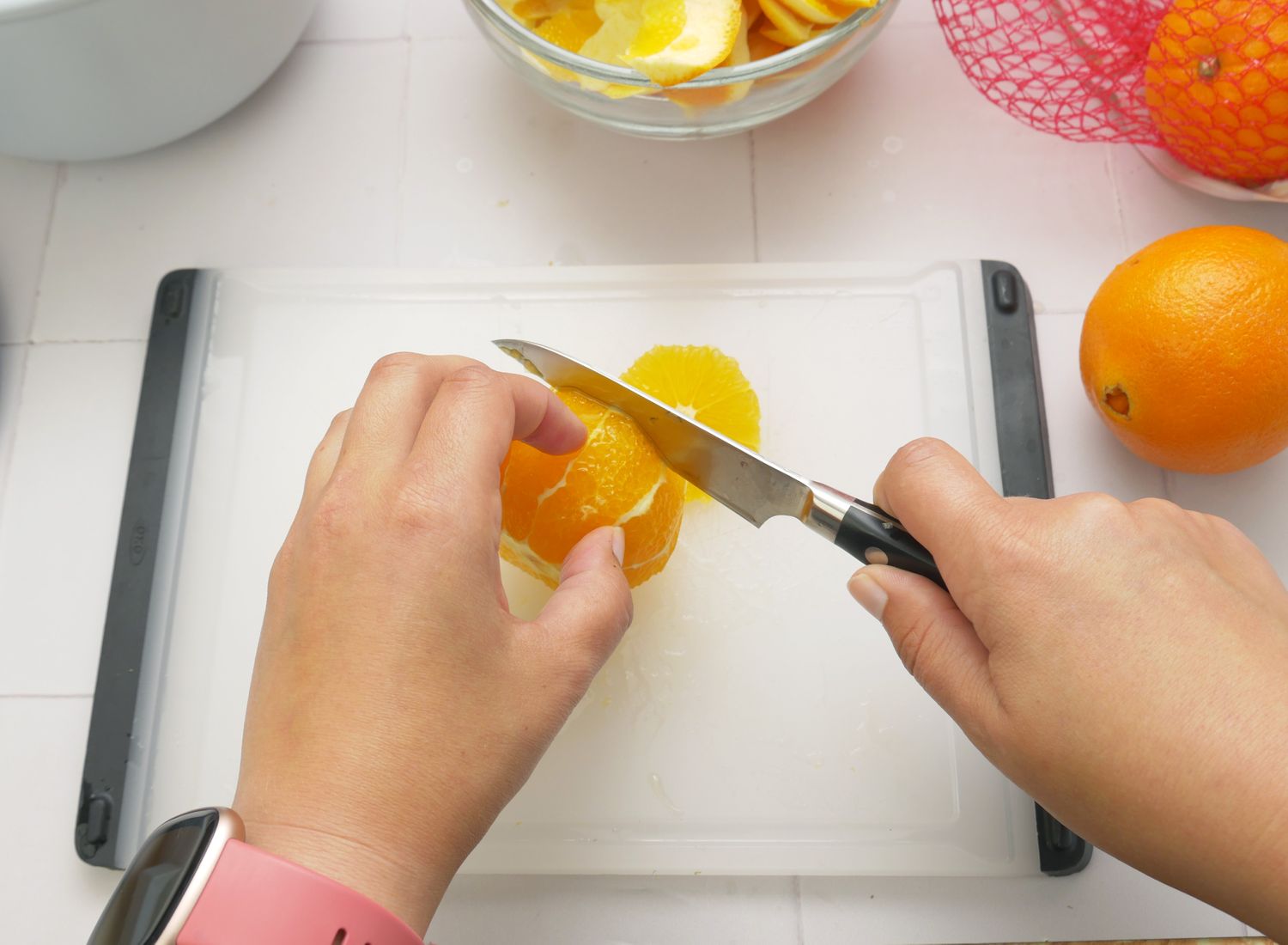 a person using the tojiro paring knife to slice an orange