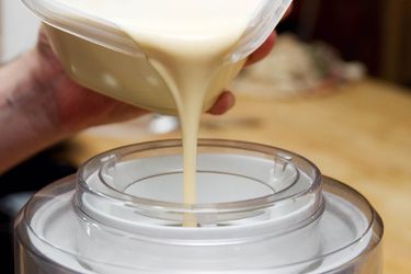 Pouring custard for ice cream into a tabletop ice cream maker. 