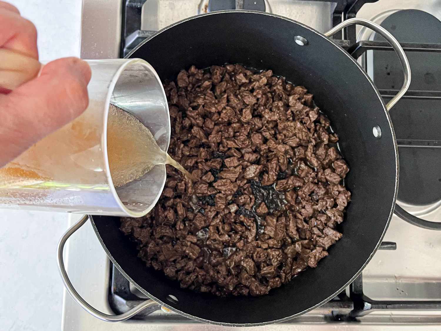 Chicken broth added to cooked beef.