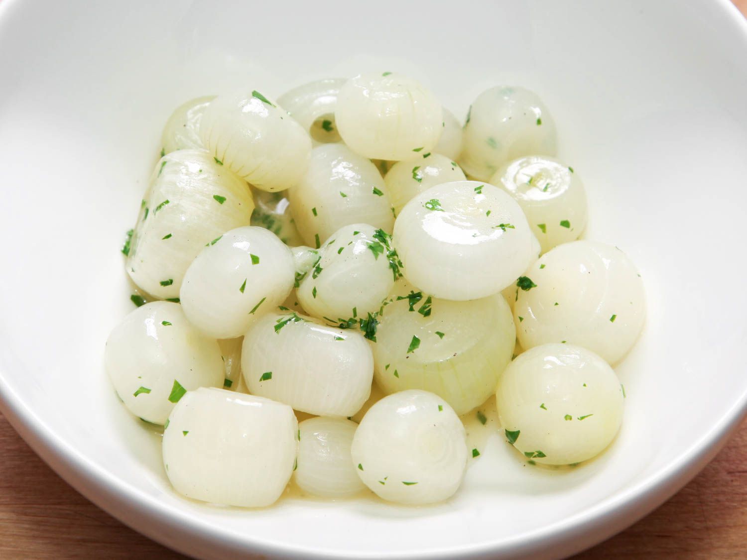 A white bowl of glazed pearl onions