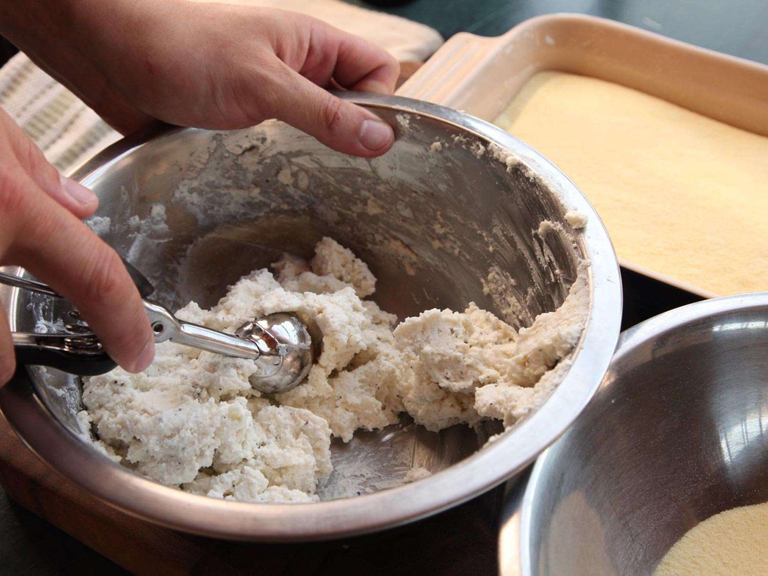 Scooping the ricotta mixture with an ice scoop. 