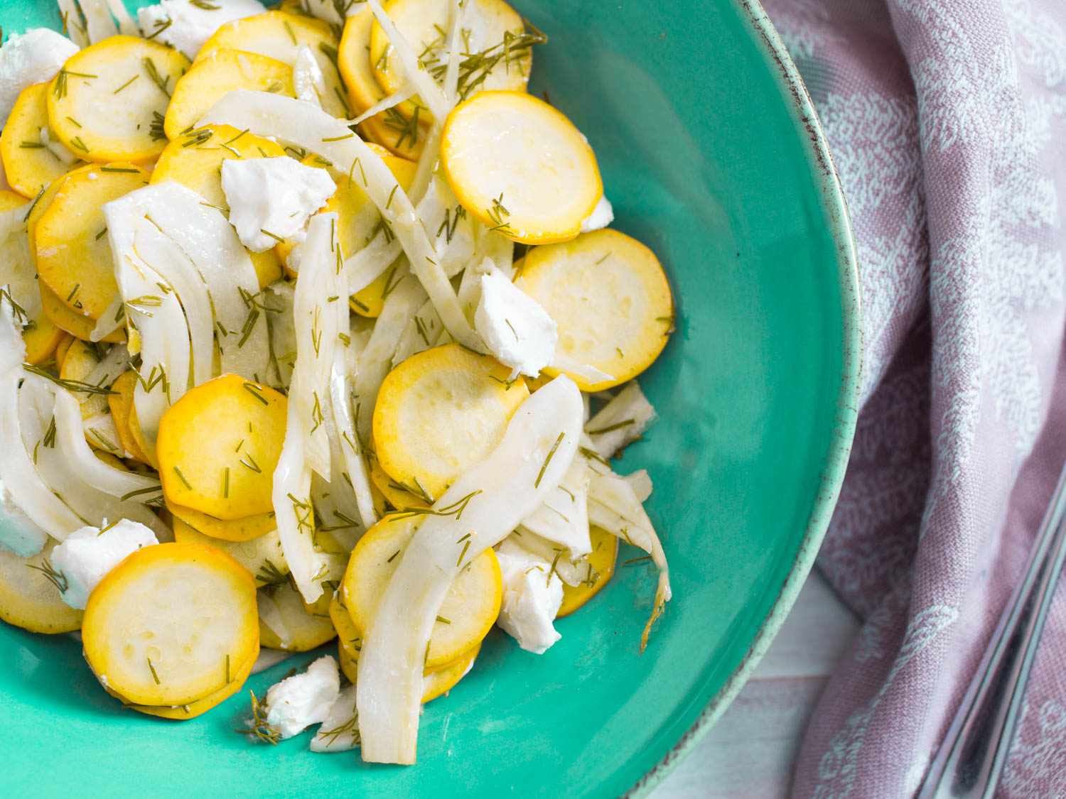 Overhead closeup of summer squash salad with goat cheese, fennel, and dill.
