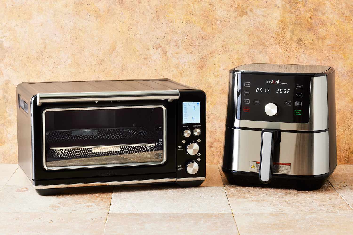 a toaster oven air fryer and an air fryer beside one another on a tan countertop