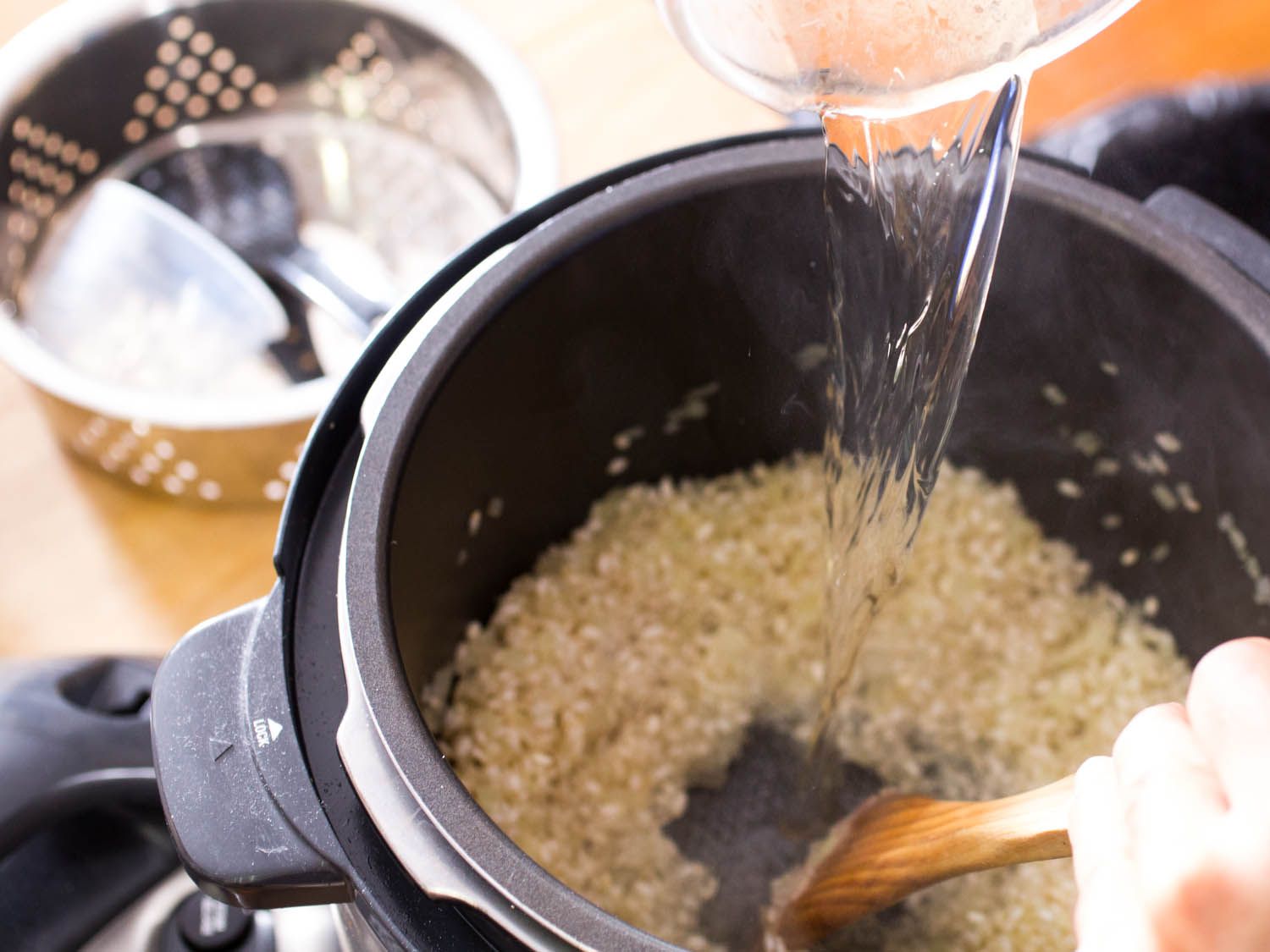 Adding wine to risotto rice in a pressure cooker. 