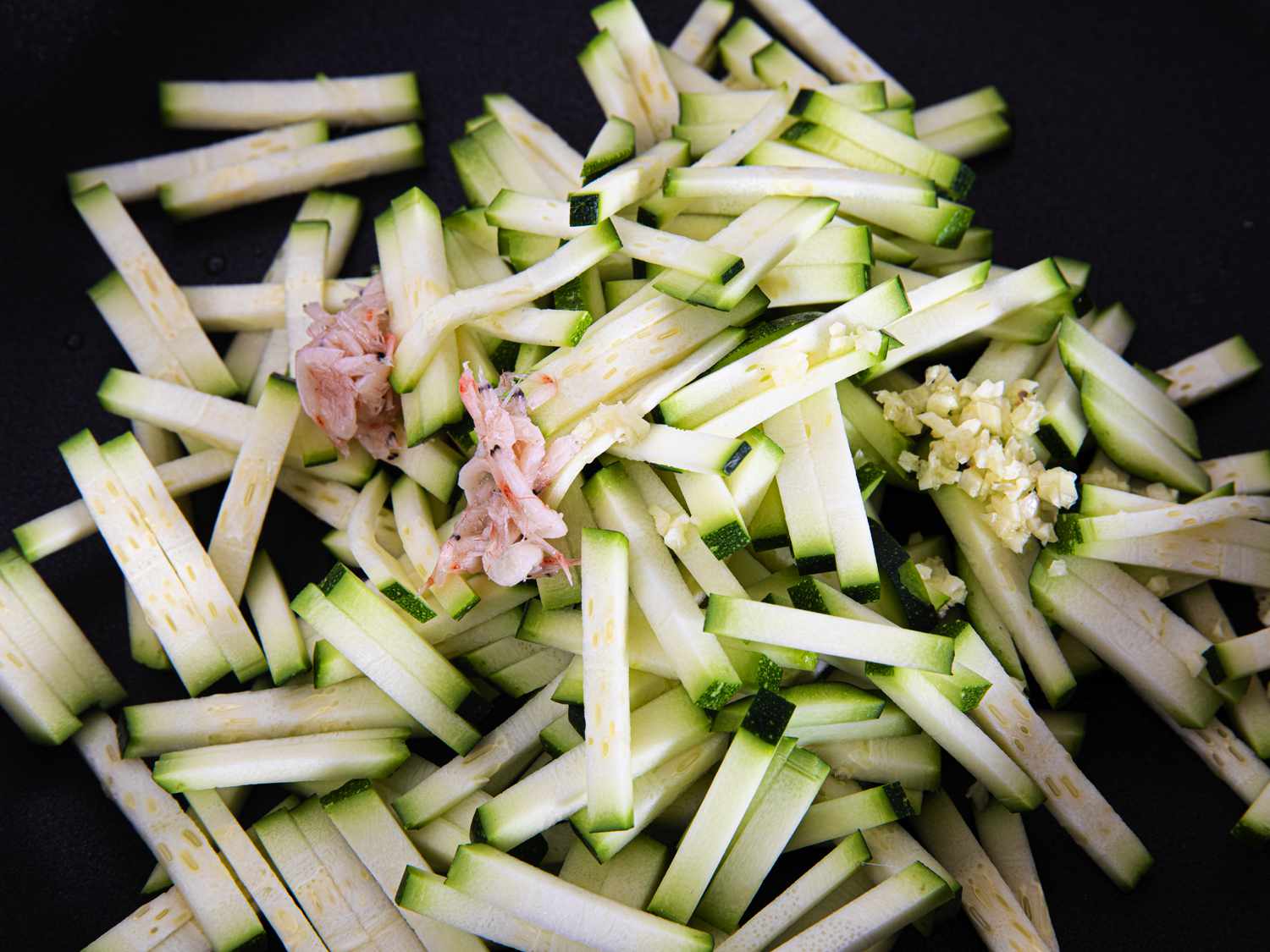 Squash topped with shrimp and seasonings in a pan