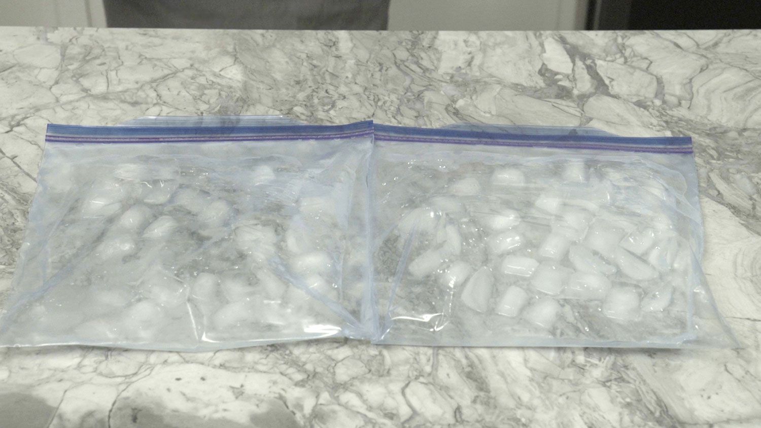 Plastic bags full of ice, spread out on a marble countertop to cool it