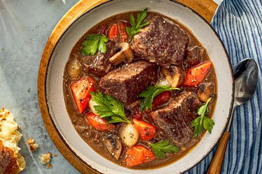 A bowl of beef bourguignon with big chunks of juicy beef, plump carrots, mushrooms and more.