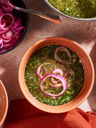 Molokhia soup in a bowl with pickled red onions.