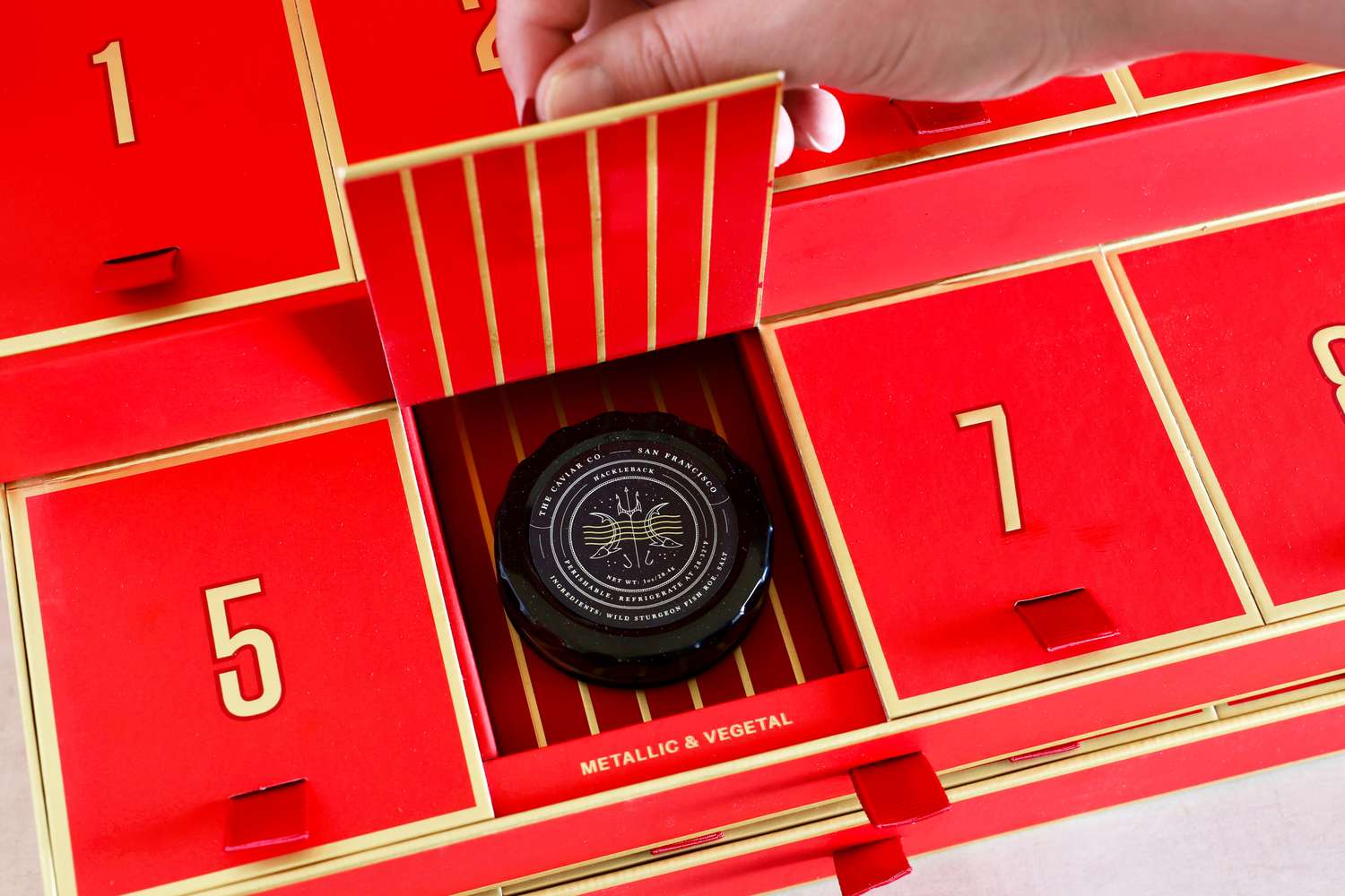 A door of the Caviar Co 12 Days of Caviar Advent calendar opened to reveal a jar of caviar