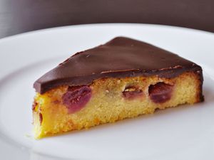 Closeup of a slice of Olive Oil Cake With Roasted Grapes and Ganache