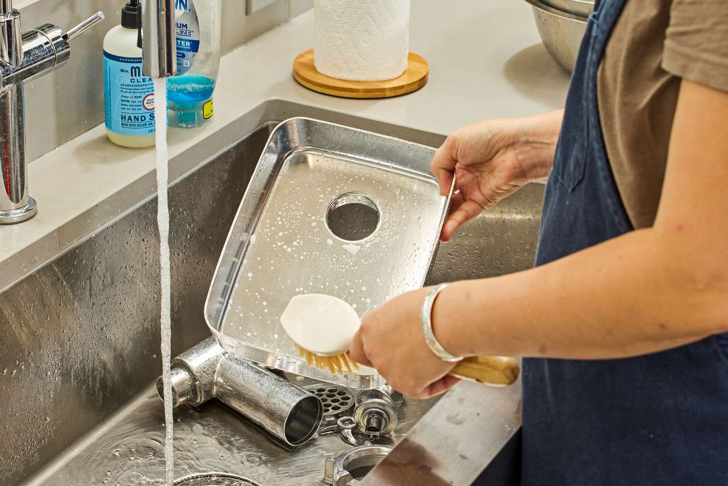 Person cleaning food tray of STX International Turboforce Classic 3000 Series Electric Meat Grinder & Sausage Stuffer