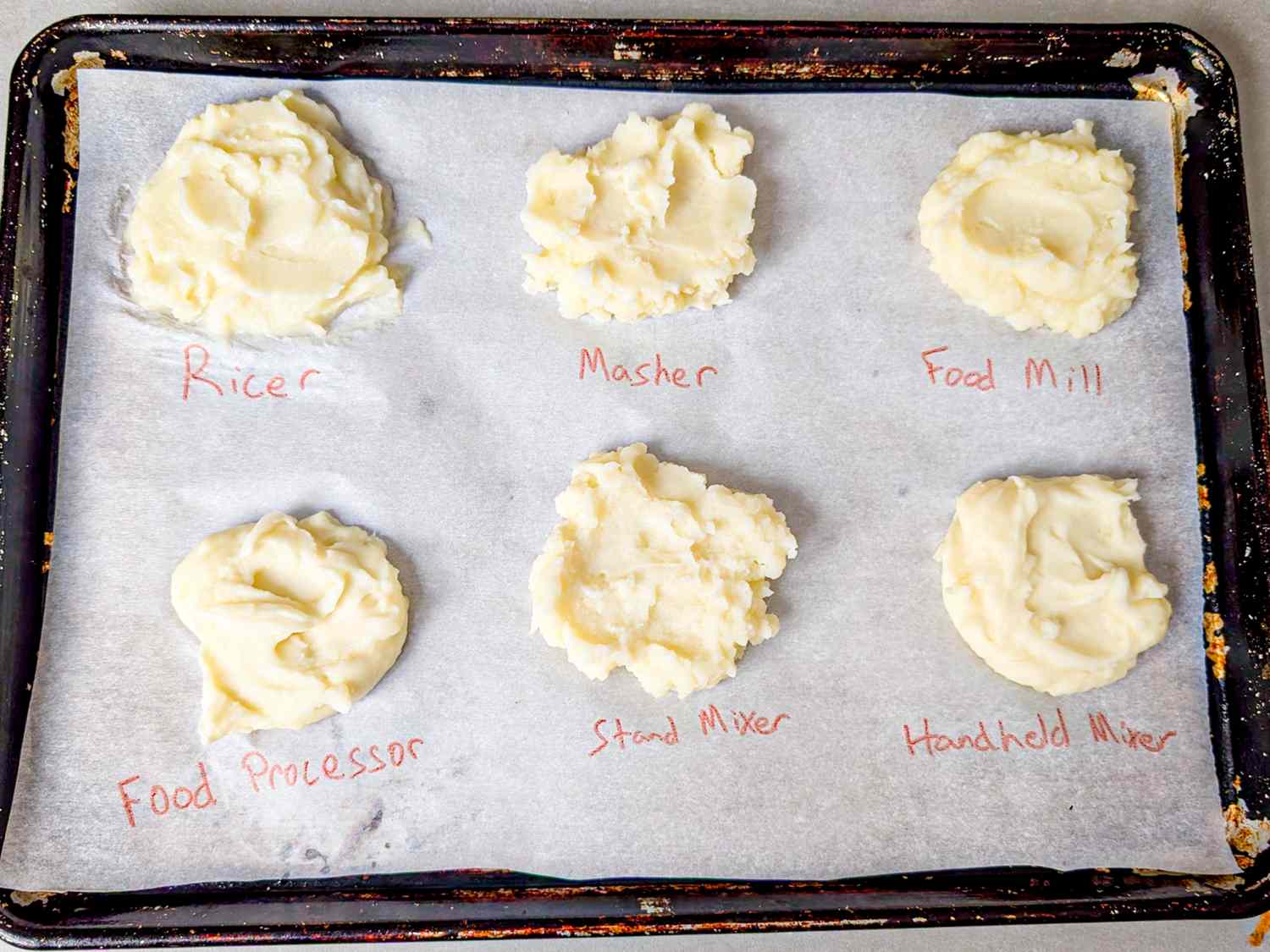 Six portions of mashed potatoes labeled by preparation method on parchment paper