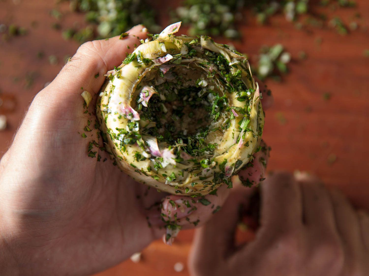 Trimmed artichoke heart smeared with garlic and herb mixture.