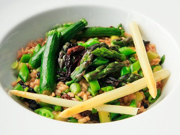 Composed spring vegetable risotto in a white bowl.