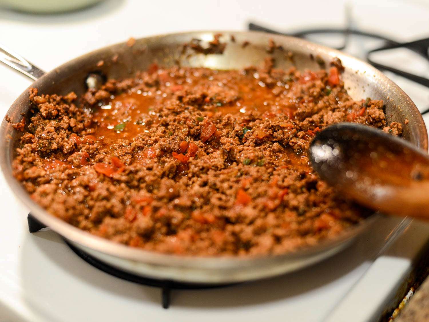 A pan of saucy spiced beef taco filling for puffy tacos